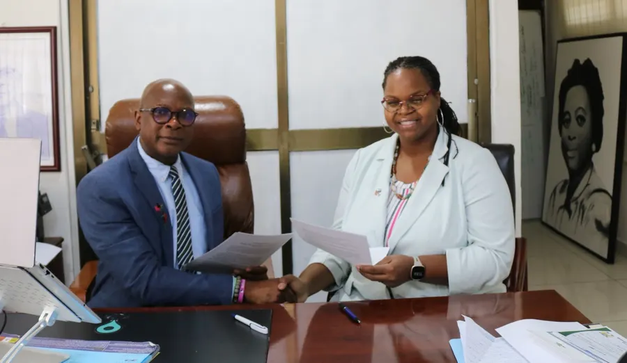 Natalie shaking hands with Sierra Leone's then Minister of Education as they sign a memorandum of understanding